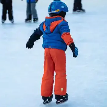 Winter fun on the ice - a child in colourful clothing has carefree fun ice skating.