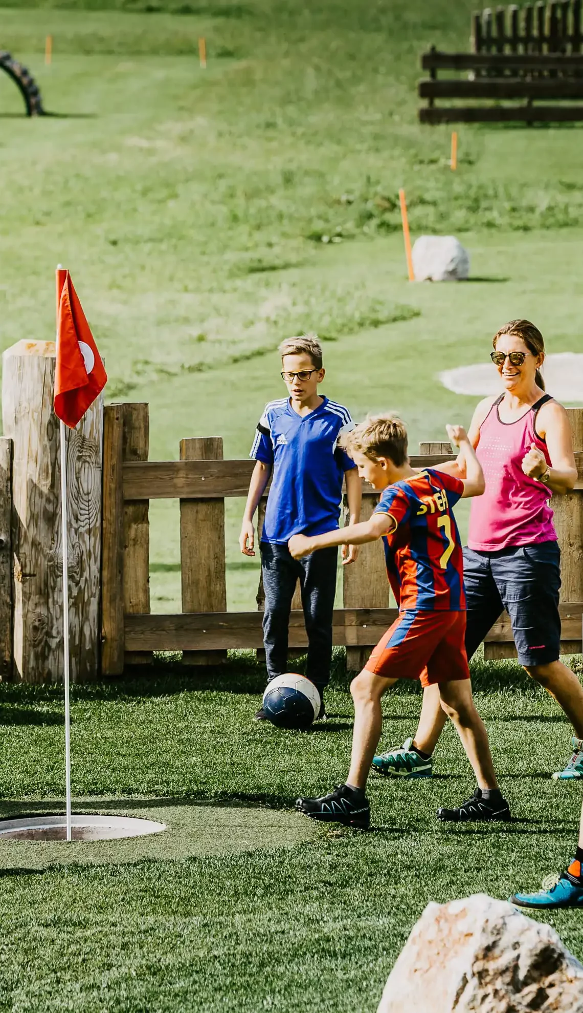 Spiel, Spaß und Teamgeist – Familien beim gemeinsamen Fußballgolf im Grünen erleben aktive Sommermomente voller Freude.