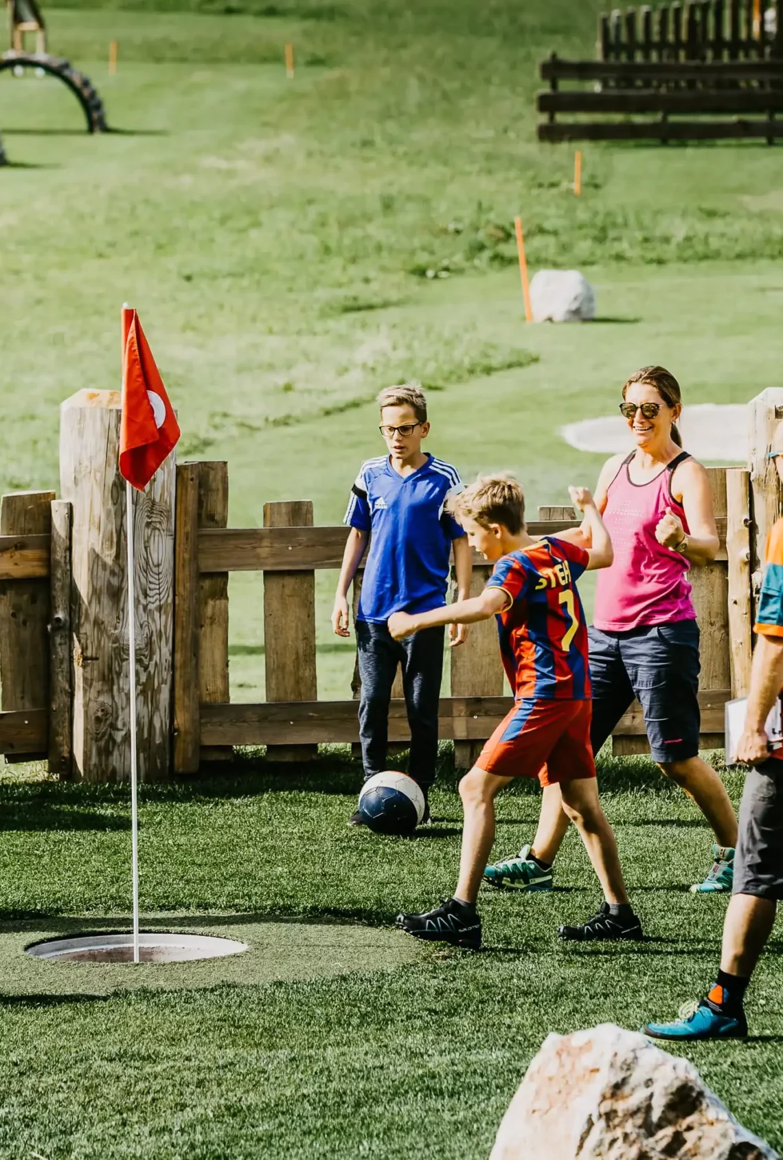 Spiel, Spaß und Teamgeist – Familien beim gemeinsamen Fußballgolf im Grünen erleben aktive Sommermomente voller Freude.