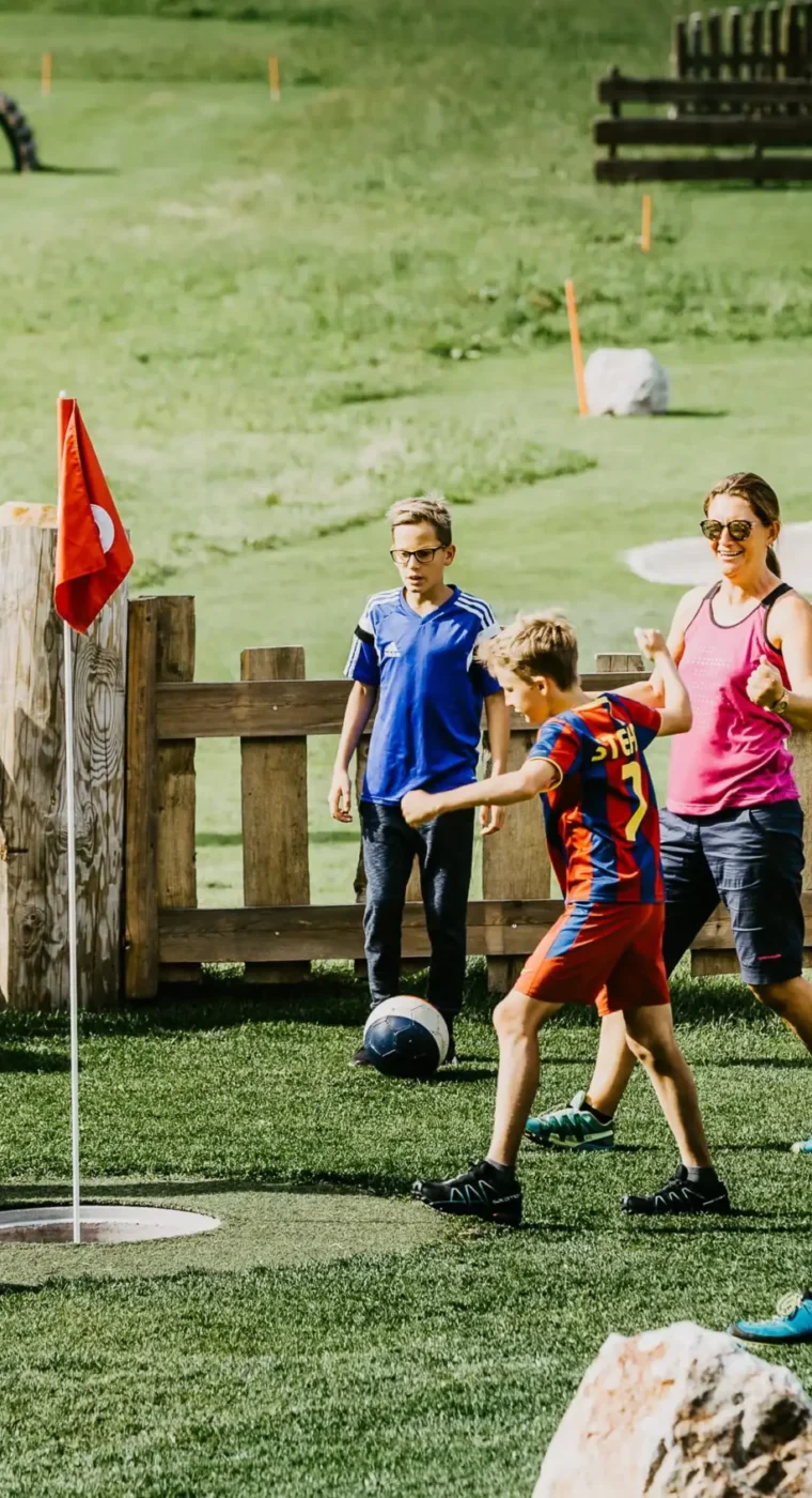 Spiel, Spaß und Teamgeist – Familien beim gemeinsamen Fußballgolf im Grünen erleben aktive Sommermomente voller Freude.