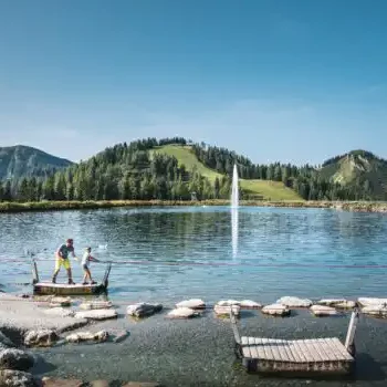 Idyllic mountain lake with play station - family time in the middle of the Alps with water fun and panoramic views of the Salzburg mountains.