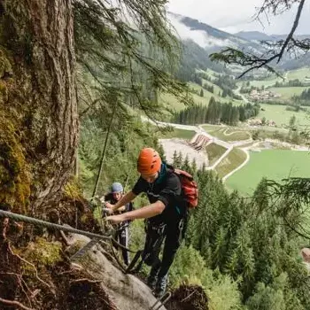 High up on the rocks - secured climbing adventure with breathtaking views of the valley and the mountain landscape in Salzburger Land.