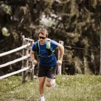Trail running with a view - sporty runners on an energetic ascent on a nature trail around Hofgut Wagrain, surrounded by green meadows and alpine flair.