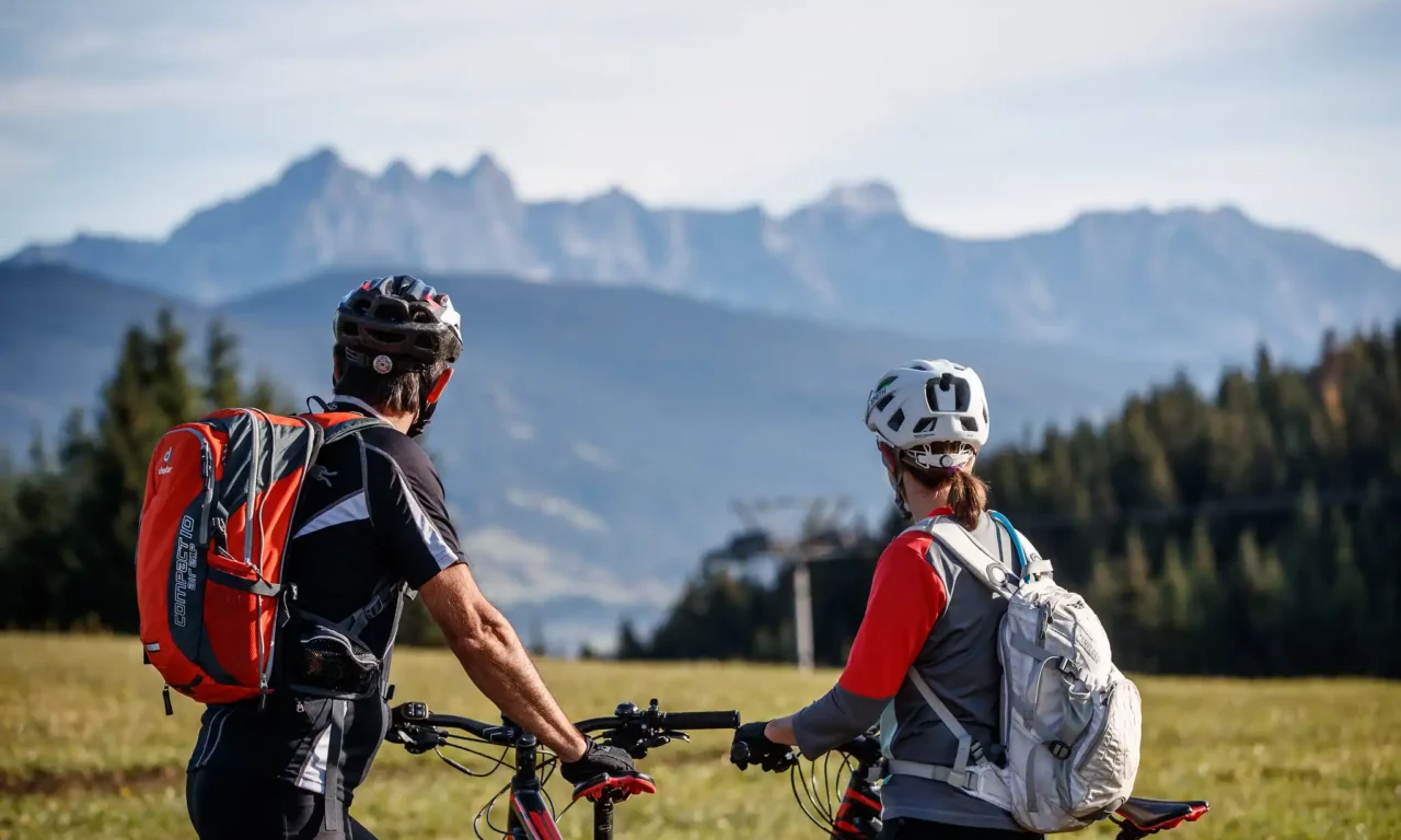 Zwei Radfahrer genießen die Aussicht auf das Bergpanorama beim Biken rund um das Hofgut Wagrain
