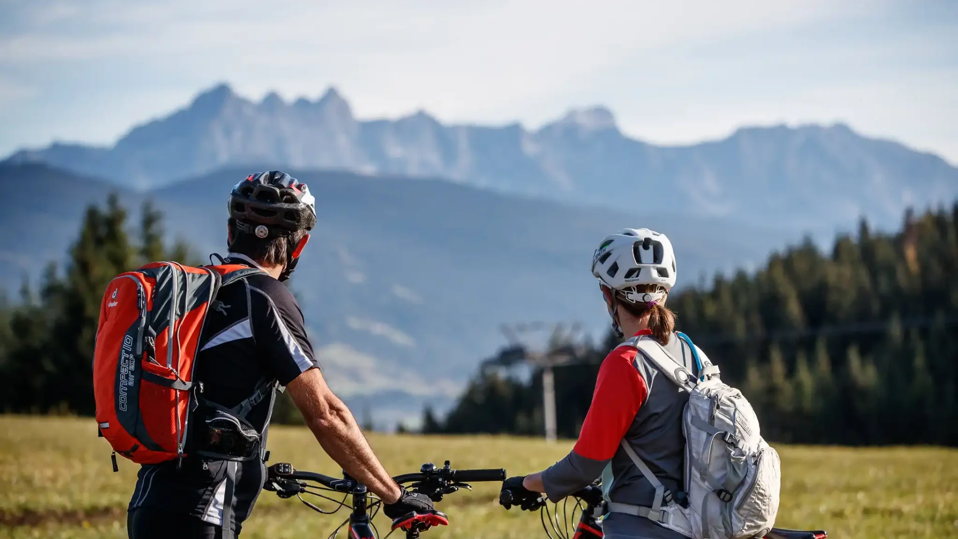 Two cyclists enjoy the view of the mountain panorama while biking around Hofgut Wagrain