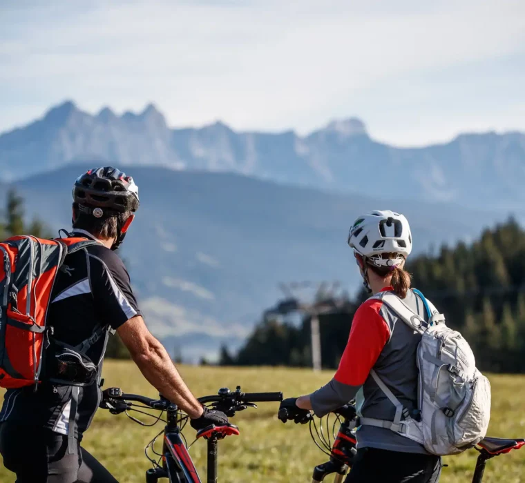 Zwei Radfahrer genießen die Aussicht auf das Bergpanorama beim Biken rund um das Hofgut Wagrain