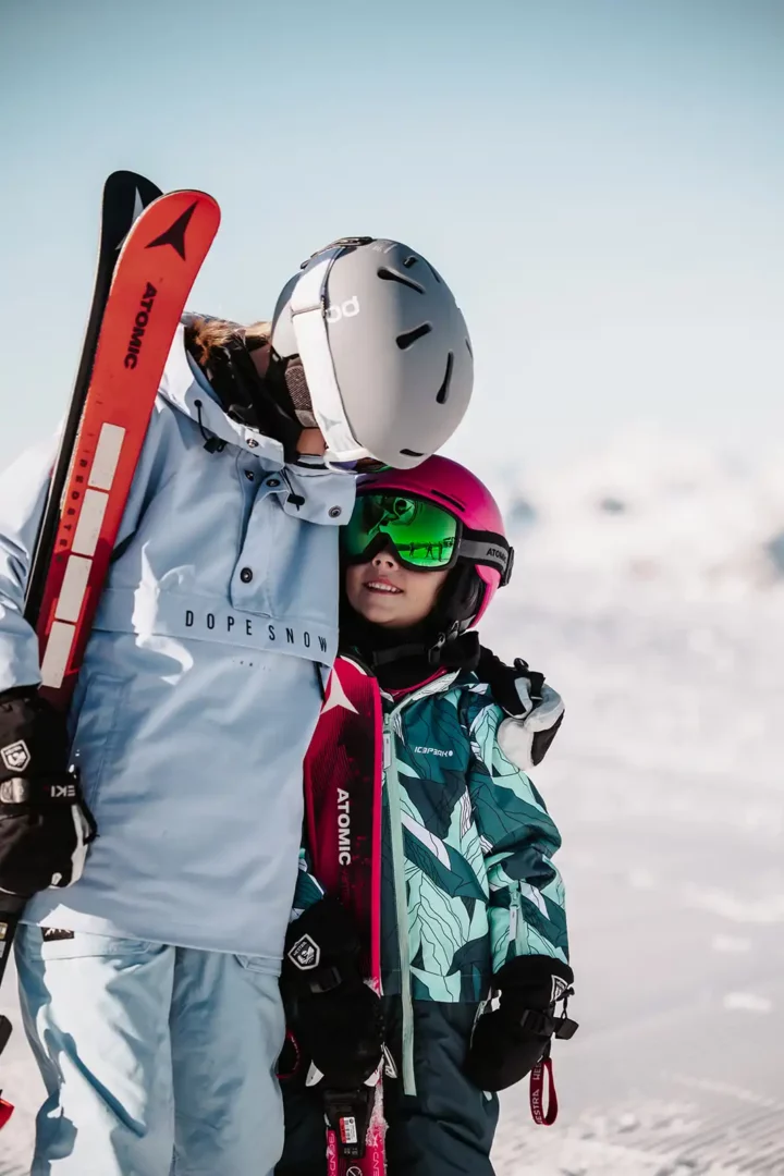 Børn med ski på sne i bjergene i Snow Space Salzburg.