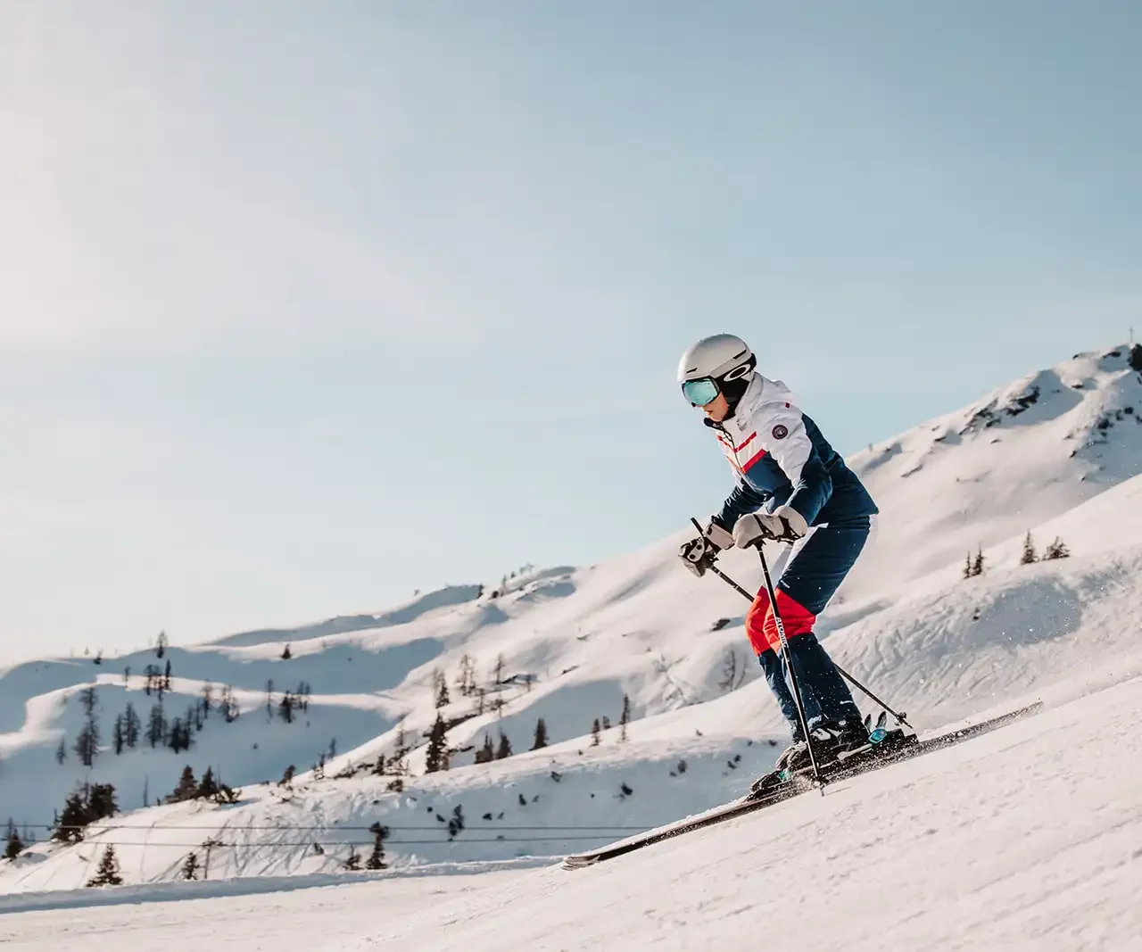 Skiløber på ski i strålende solskin på pisterne i Ski Amadè.