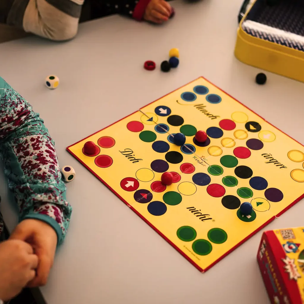 Hofgut-Wagrain-Apartment-Lifestyle-Resort-Erleben-für-Kinder-Kinderbetreuung Children play board games on a family vacation at Hofgut Wagrain.