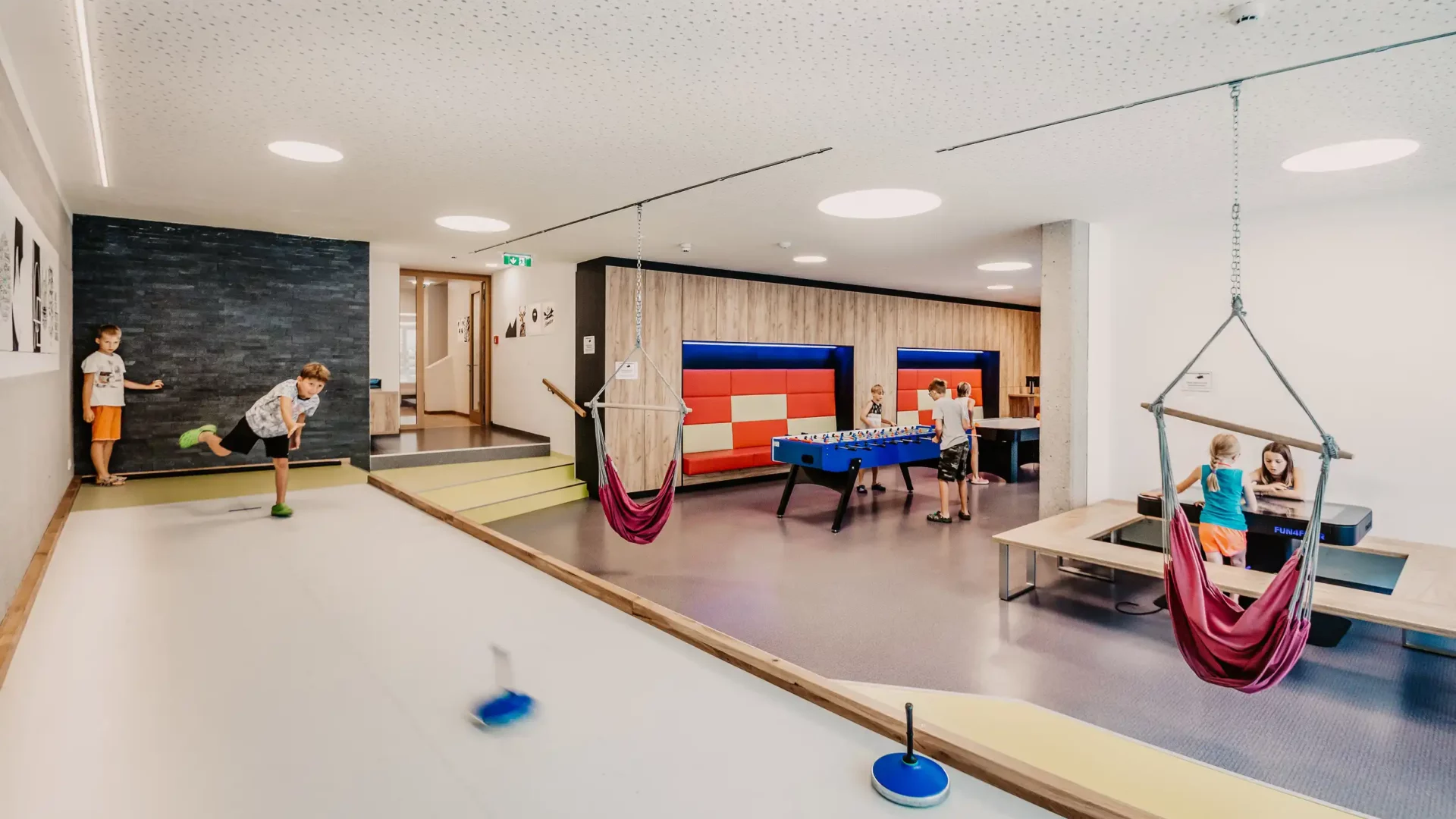 Modern indoor games world at Hofgut Wagrain with bowling alley, table football, hanging chairs and games tables - ideal for children and family holidays in Austria