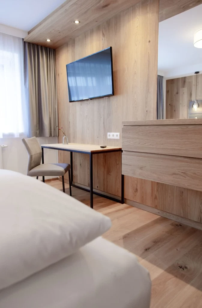 Modernes Apartmentzimmer im alpinen Design mit Schreibtisch und Flat-TV im Hofgut Wagrain