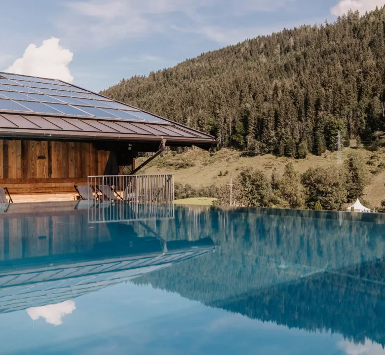 Infinity pool with panoramic views of the Salzburg mountains at Hofgut Wagrain