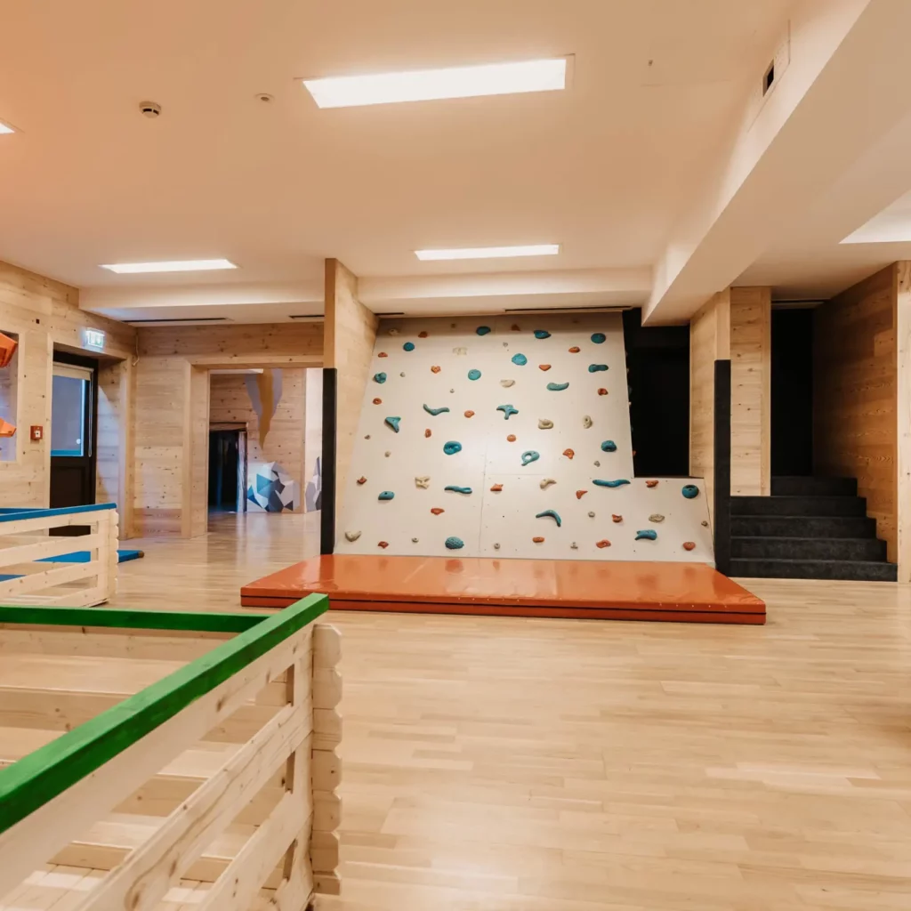 Hofgut-aparment-lifestyle-resort-wagrain-133 Climbing wall in the indoor play area at Hofgut Wagrain - playful adventure and exercise for little climbers in a safe environment.