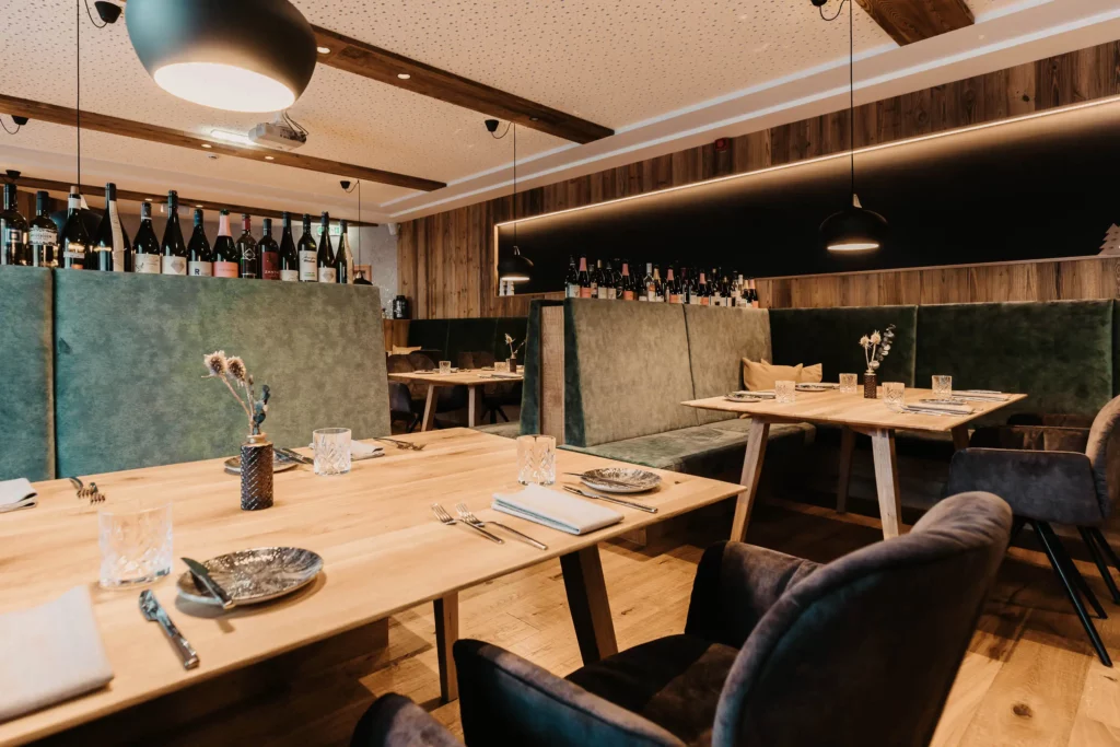 Hofgut-aparment-lifestyle-resort-wagrain-156 Gemütliche Restaurantatmosphäre im Hofgut Wagrain mit stilvoller Holzoptik, eleganter Tischkultur und einladender Sitzbank – Genussmomente für die ganze Familie im alpinen Lifestyle-Ambiente.