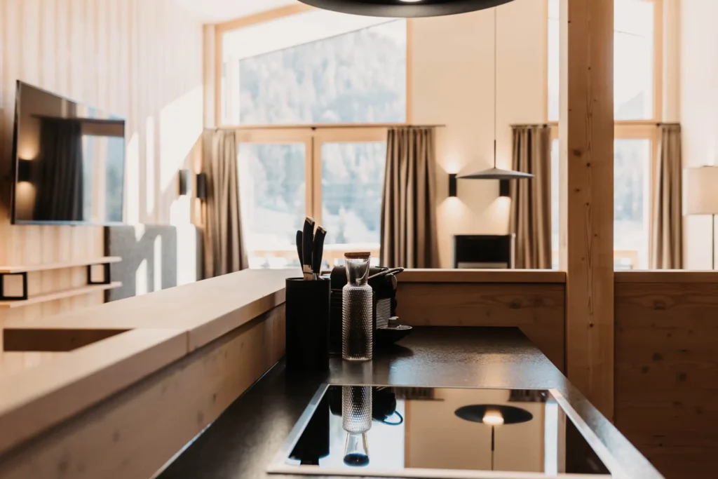 Open-plan kitchen at Hofgut Wagrain with modern appliances, stylish details and a breathtaking view of nature.