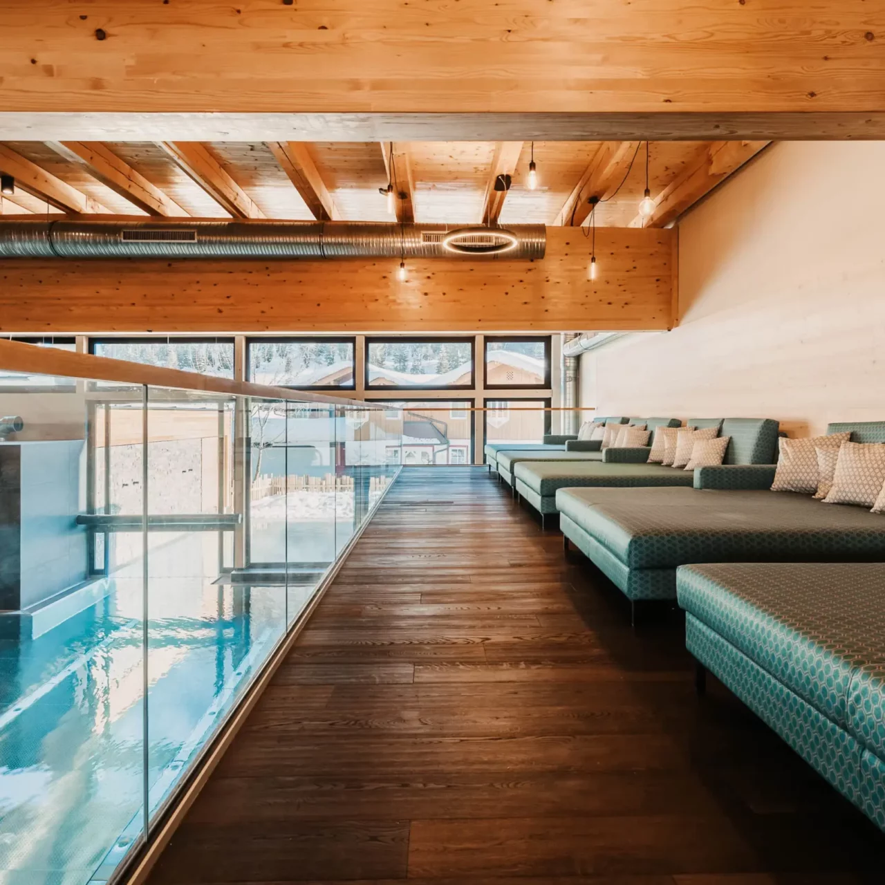 Quiet wellness lounge with cosy loungers and a view of the indoor pool at Hofgut Wagrain.