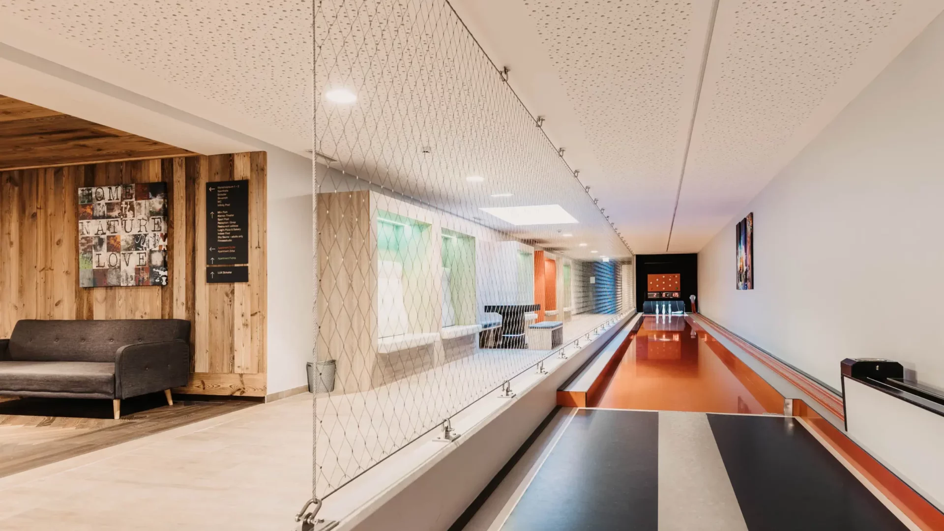 Modern bowling alley at Hofgut Wagrain with a cozy seating area and stylish design.