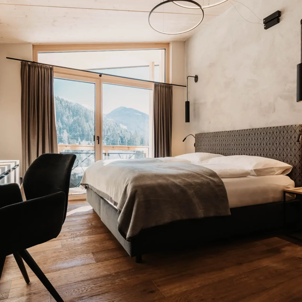 Alpine charm meets modern design: cosy bedroom with panoramic views and stylish details.