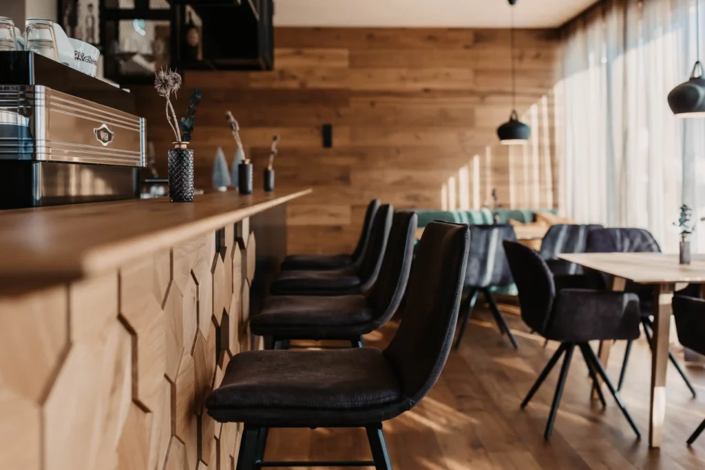 Hofgut-aparment-lifestyle-resort-wagrain-vamoos-bar-83 Elegante Bar im Hofgut Wagrain mit stilvoller Holzverkleidung, gemütlichen Barhockern und alpinem Flair – perfekter Ort für entspannte Genussmomente.