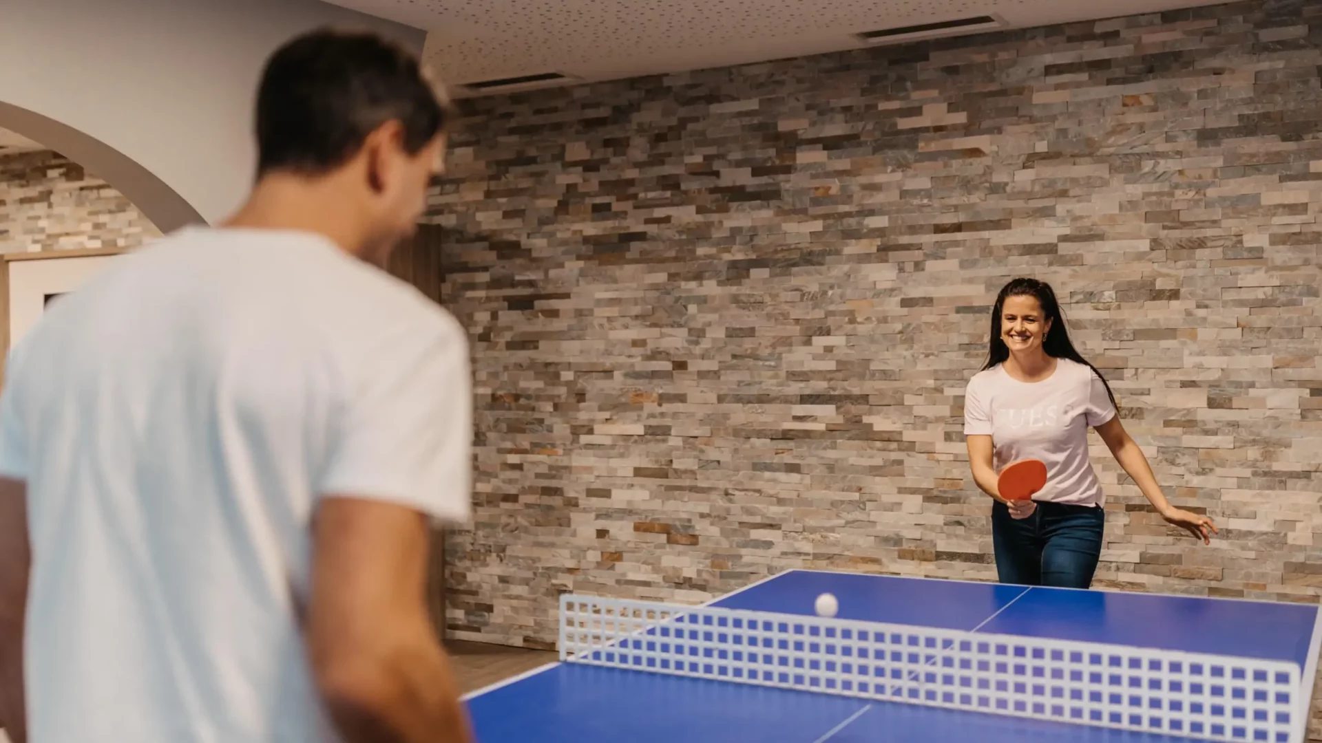 Sporty fun on holiday: a table tennis duel with lots of laughter and exercise - active time for couples at Hofgut Wagrain.