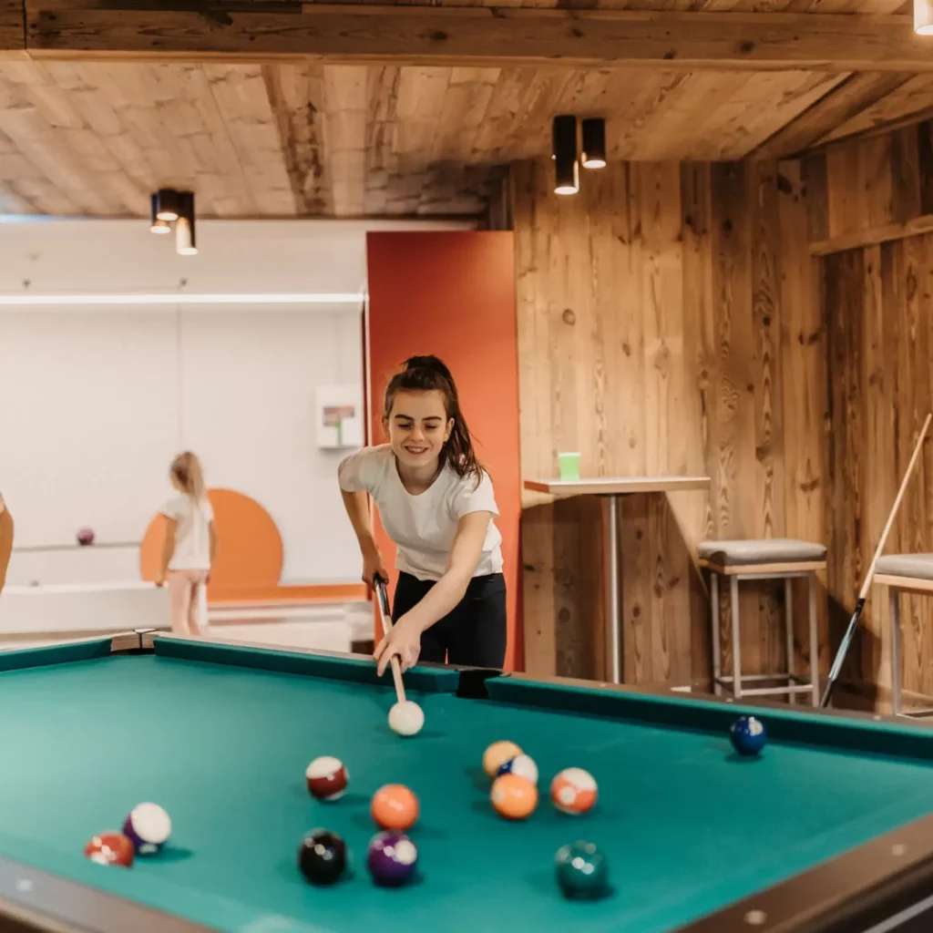 Hofgut-wagrain-apartment-66 Fun for young and old: family time at the pool table in the stylish Games Area at Hofgut Wagrain - laugh, aim and enjoy together.