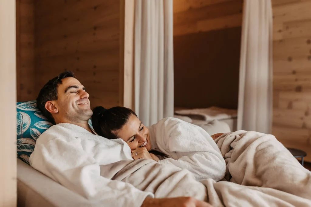 Hofgut-wagrain-apartment-adults-only-Elternzeit-259 Enjoy togetherness at Hofgut Wagrain - a relaxed couple wrapped up in fluffy bathrobes on a cosy lounger in the relaxation room. The warm wooden look and cosy atmosphere make this moment unforgettable.