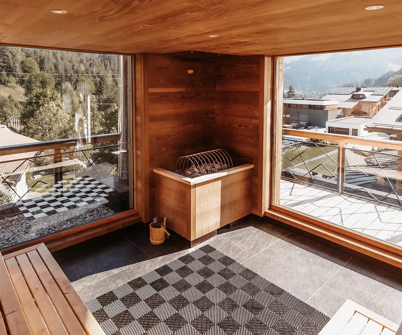 Moderne Sauna mit großen Fenstern und Blick auf die umliegende Berglandschaft.