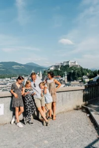 Family with city map enjoying the view over Salzburg and the Hohensalzburg Fortress in summer.