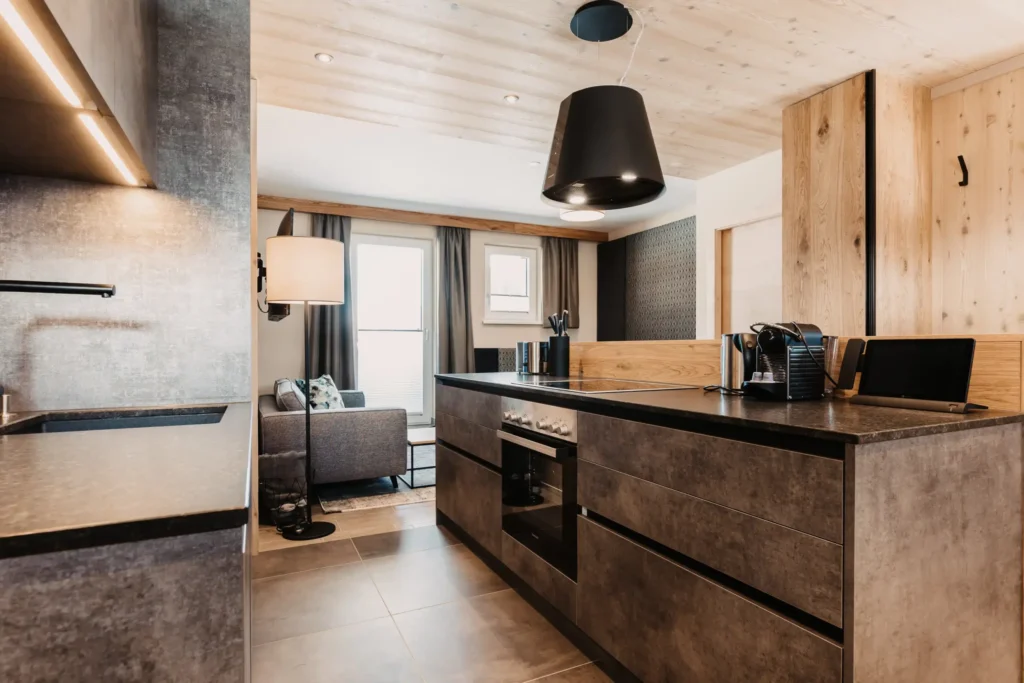 High-quality kitchenette in alpine industrial design: the stylish furnishings of the flat at Hofgut Wagrain make cooking together an enjoyable experience.