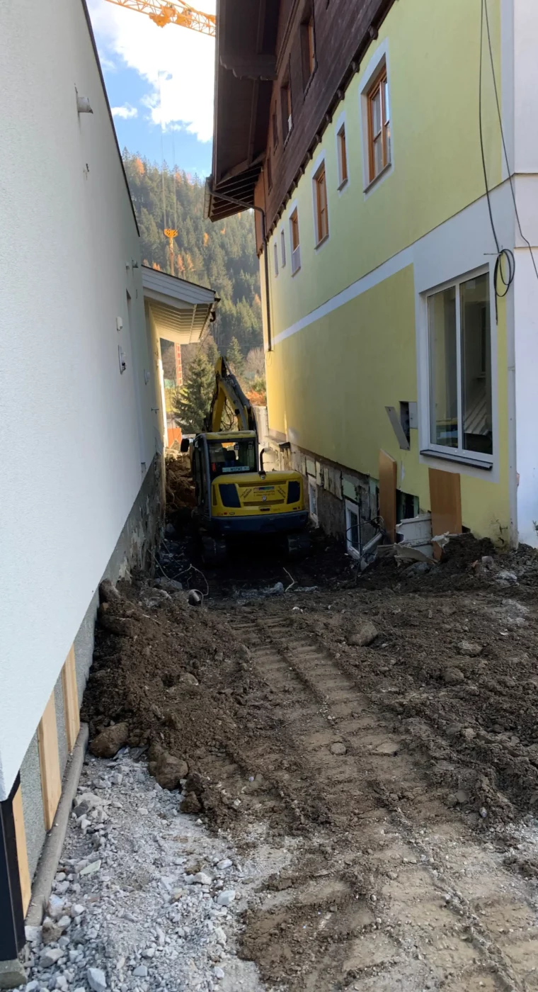 Excavation work between two buildings at Hofgut Wagrain - construction phase for new connection.