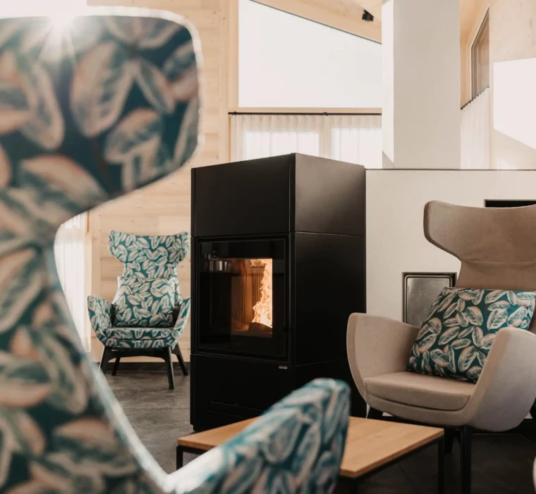 Cosy fireplace lounge in the adults-only wellness area at Hofgut Wagrain - with stylish wing chairs and panoramic views.