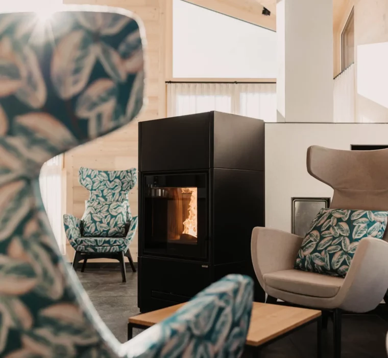 Gemütliche Kaminlounge im Adults-only Wellnessbereich des Hofgut Wagrain – mit stilvollen Ohrensesseln und Panoramablick.