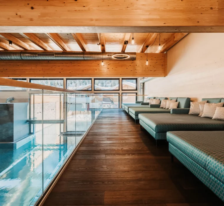 Quiet wellness lounge with cosy loungers and a view of the indoor pool at Hofgut Wagrain.