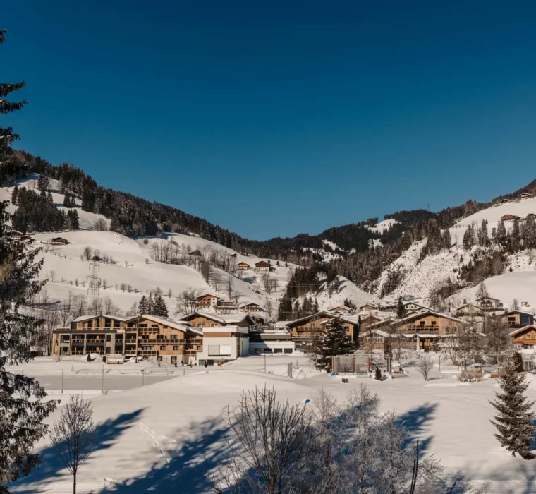 Das Hofgut Wagrain eingebettet in die verschneite Winterlandschaft – alpine Idylle und Ruhe mit Weitblick über die Berge des Salzburger Landes.