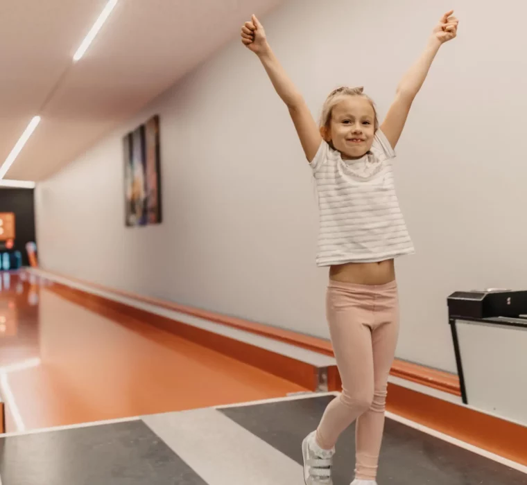 Strahlender Kegelerfolg: Glücksmomente für Kinder auf der hauseigenen Kegelbahn im Hofgut Wagrain – Spiel & Spaß für die ganze Familie.