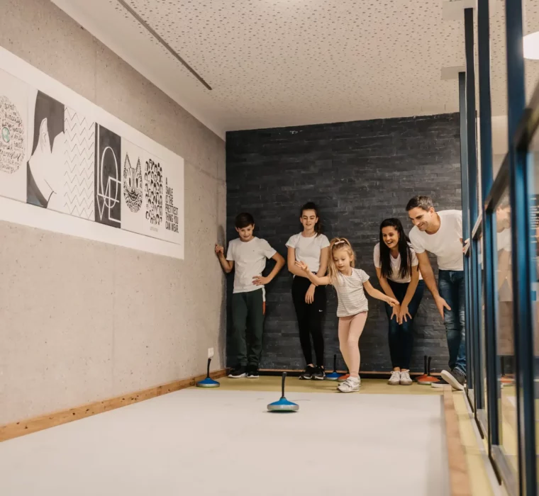 Zielsicherer Familienspaß beim Indoor-Stockschießen: Gemeinsam lachen, anfeuern und treffen – aktive Urlaubsmomente im Hofgut Wagrain.