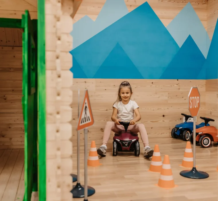 Playful driving fun in the Mini Park at Hofgut Wagrain: A girl whizzes through a small course on a bobby car - fun, safe and perfect for little explorers.