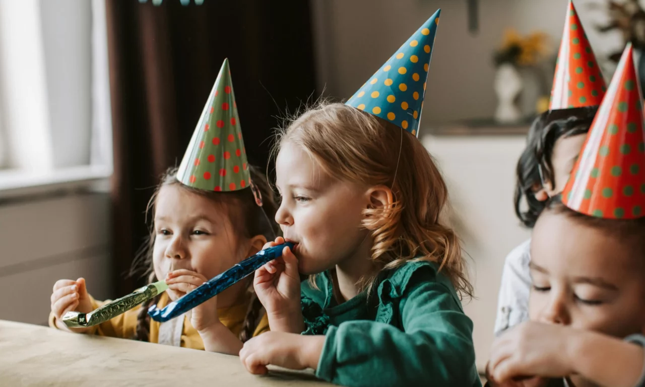 Children's birthday party with party hats and horns - cheerful celebration with small children