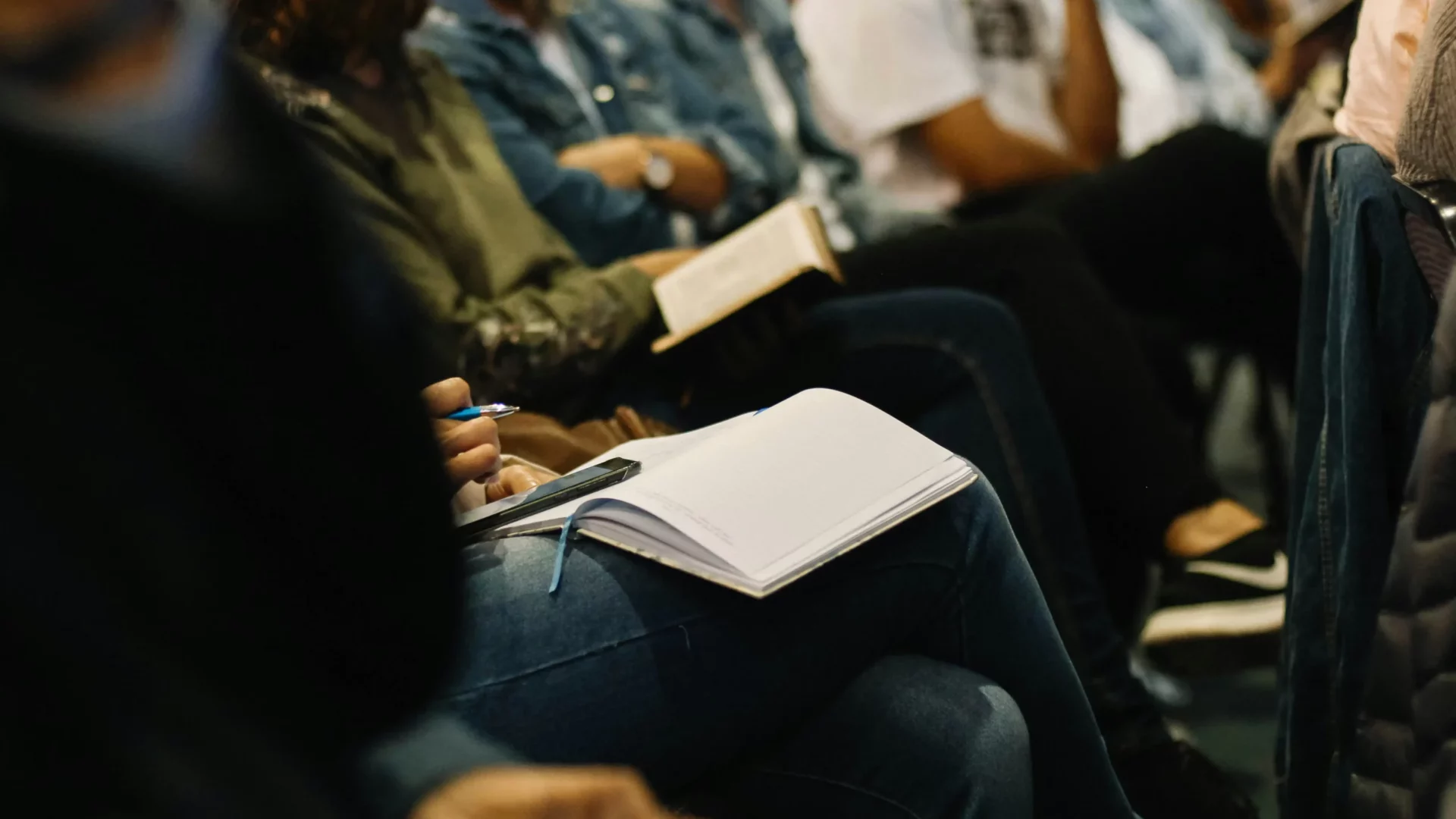 Participants at a seminar take notes in the conference room during a presentation