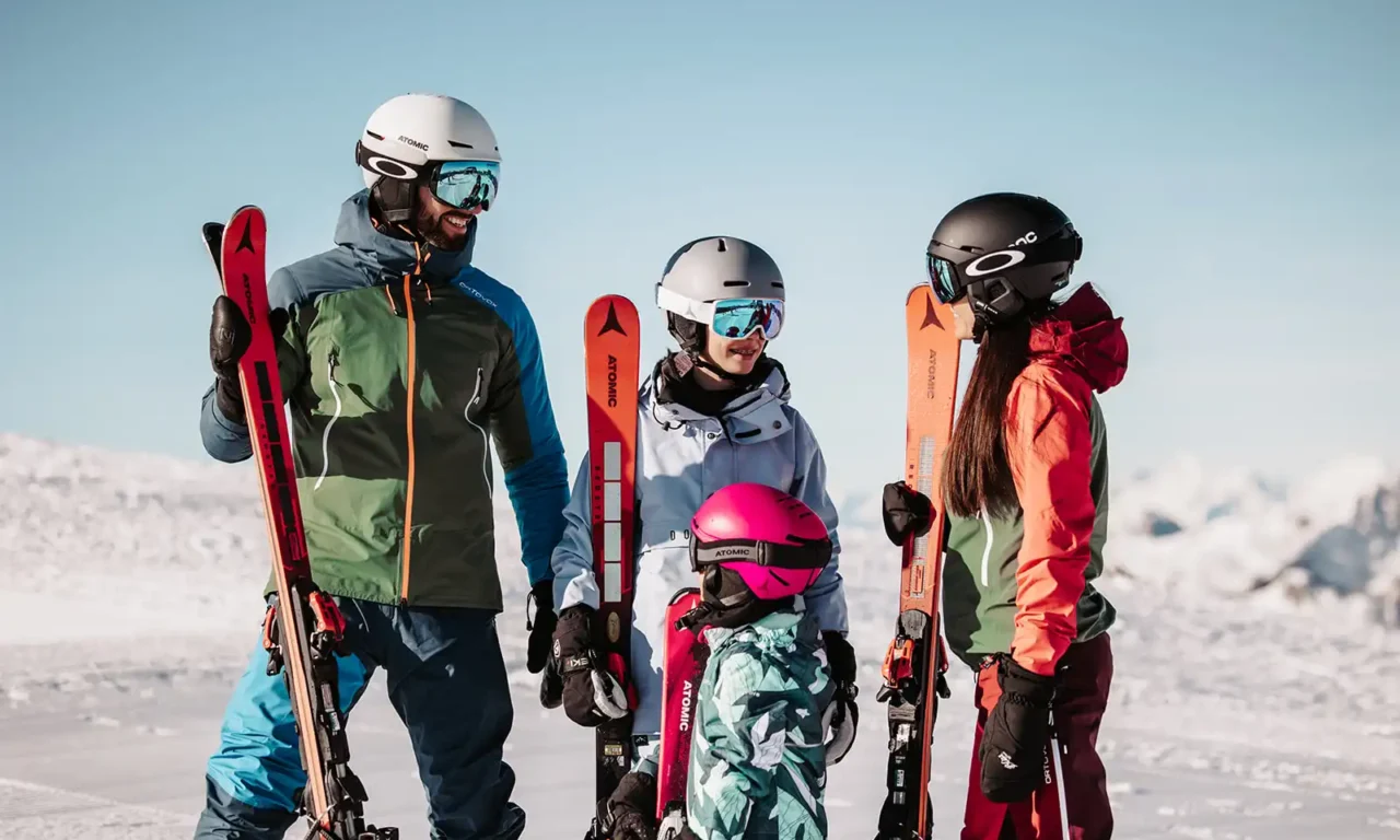 Winter happiness for young and old - a smiling family on skis against a fantastic Alpine backdrop at Hofgut Wagrain.