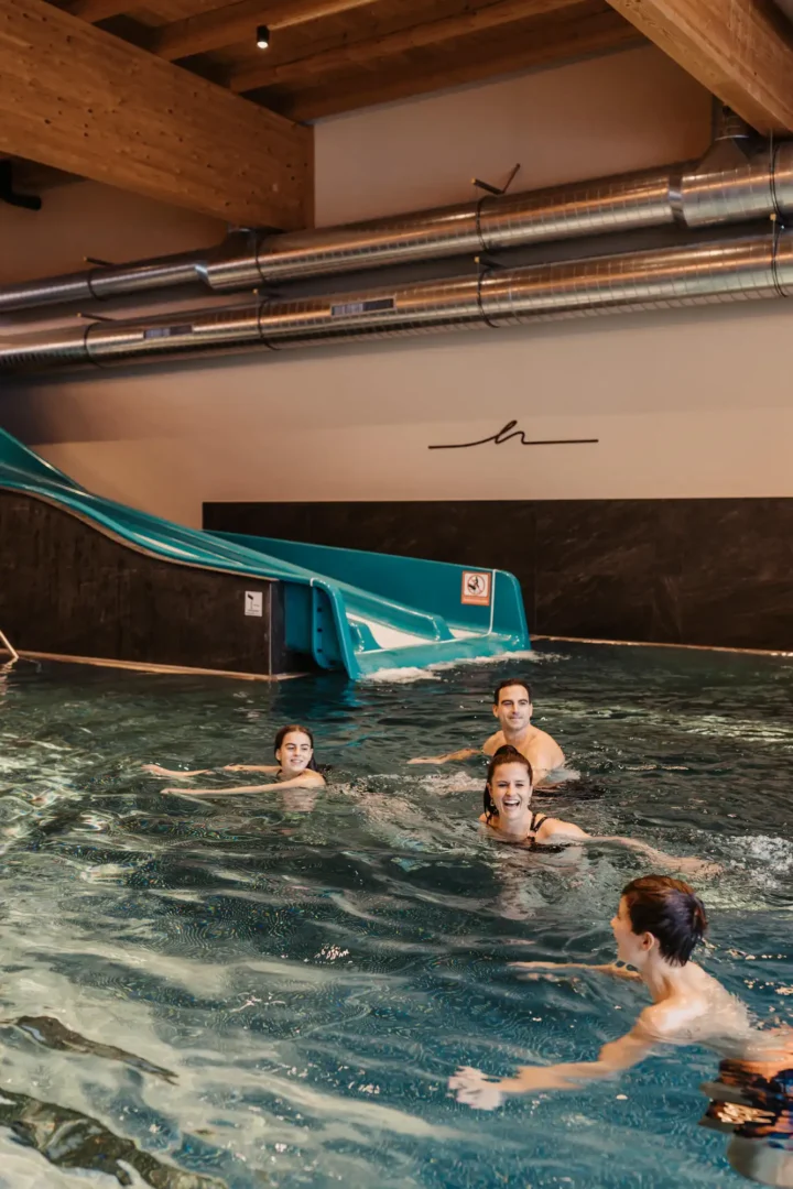 Familie im Indoor-Pool mit Rutsche im Hofgut Wagrain