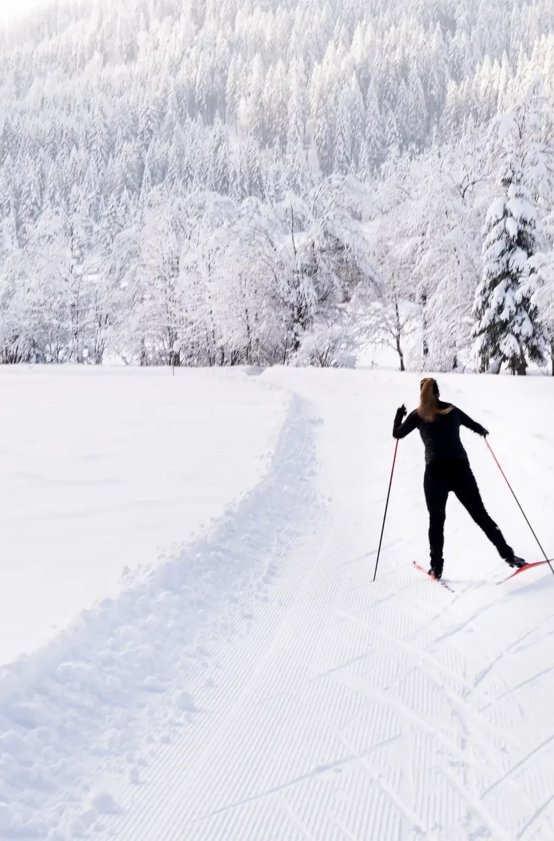 Langläuferin auf der Loipe in der verschneiten Winterlandschaft von Wagrain-Kleinarl