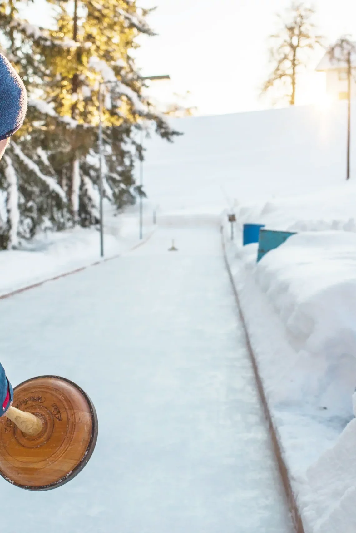 Tradition trifft Wintervergnügen – Eisstockschießen inmitten verschneiter Berglandschaft bei Sonnenuntergang.