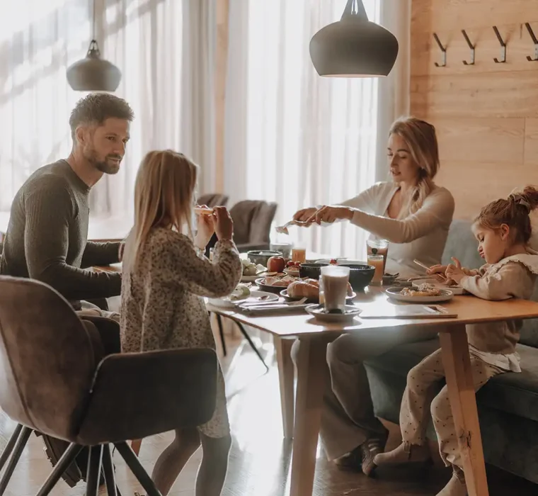 The family of four sit at the breakfast table at the connoisseur breakfast in the Hofgut Wagrain-Restaurant vaMoos.