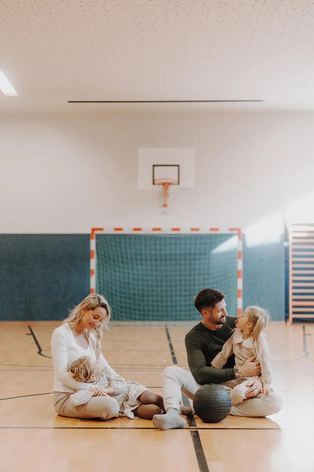 Eine vierköpfige Familie sitzt gemeinsam in der Sporthalle der Spielewelt im Hofgut Wagrain.
