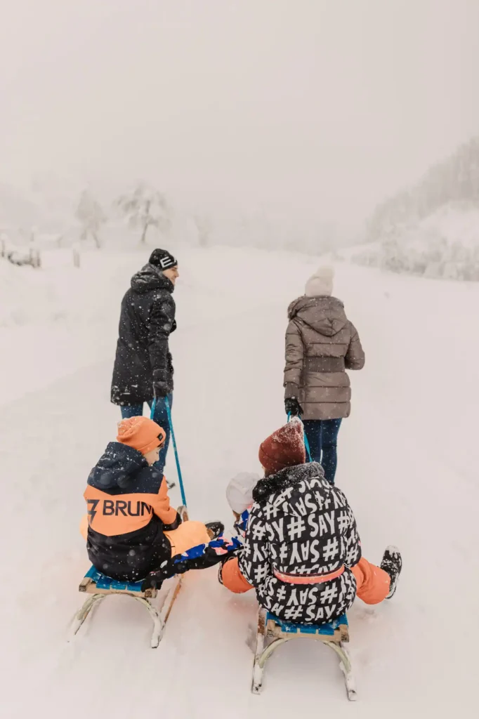 Familie beim Rodeln im Schnee in Wagrain – Winterurlaub mit Kindern voller Bewegung und gemeinsamer Erlebnisse