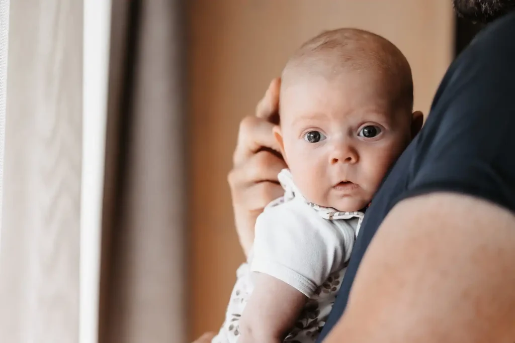 Süßes Baby getragen an Papas Brust im Urlaub im Hofgut Wagrain.