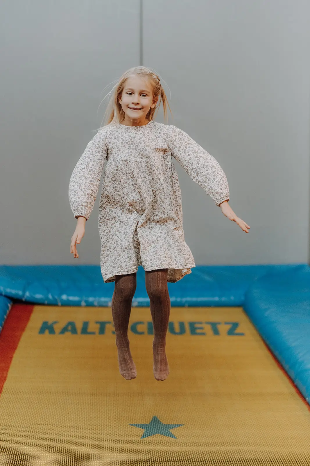 Dziecko skacze wysoko na trampolinie w sali zabaw Hofgut Wagrain.